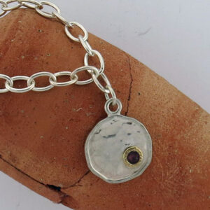 Trendy sterling silver bracelet with two tone and a Garnet charm hanging